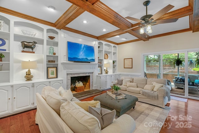 5750 Hemby Rd, Matthews, NC 28104 - living room featuring wood finished floors, beamed ceiling, ceiling fan, a fireplace with raised hearth, and coffered ceiling