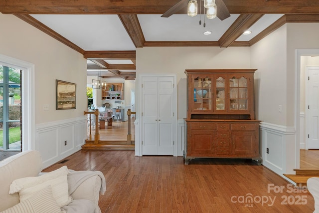 5750 Hemby Rd, Matthews, NC 28104 - living room featuring wood finished floors, beam ceiling, a wainscoted wall, coffered ceiling, and ceiling fan with notable chandelier