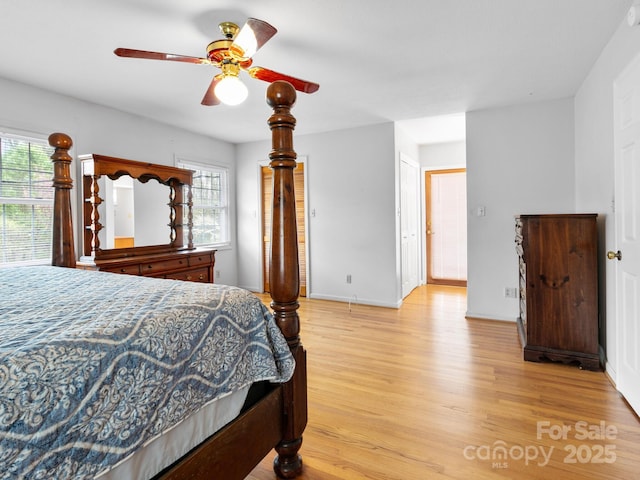 bedroom with light wood finished floors, ceiling fan, and baseboards