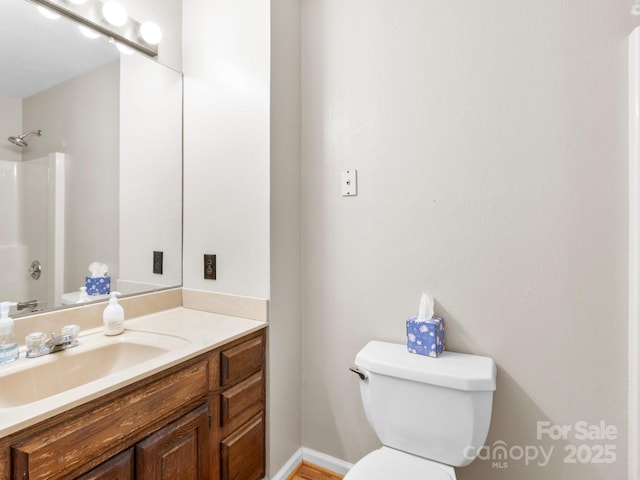 bathroom featuring toilet, vanity, and walk in shower