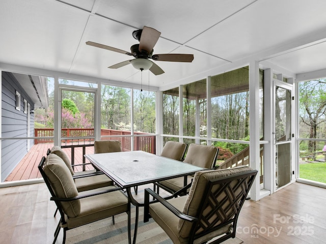sunroom featuring outdoor dining space and a ceiling fan