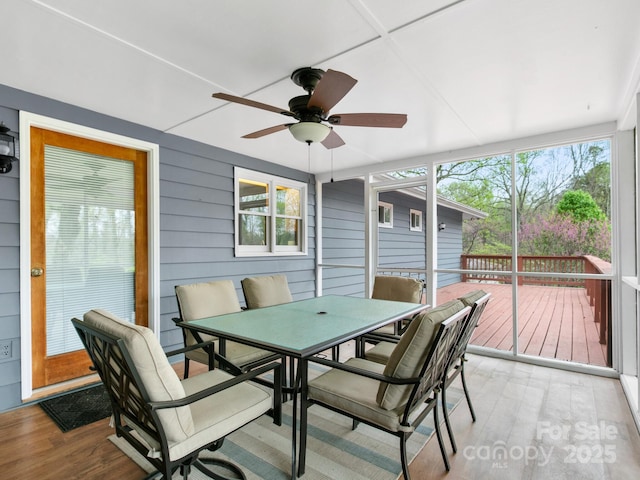 sunroom / solarium with outdoor dining space and ceiling fan