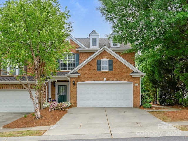 traditional home with brick siding, concrete driveway, and an attached garage
