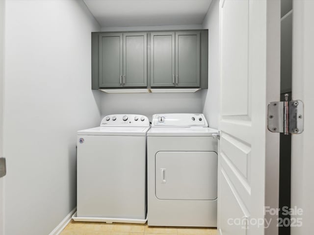 laundry area featuring washer and dryer, cabinet space, and baseboards