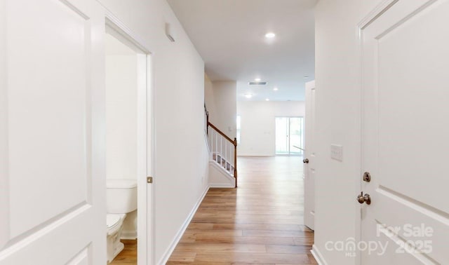 corridor with recessed lighting, baseboards, stairway, and light wood-style floors