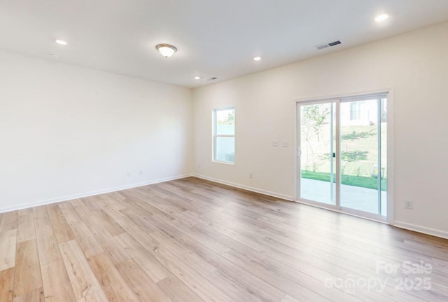 empty room featuring light wood-style flooring, baseboards, visible vents, and recessed lighting