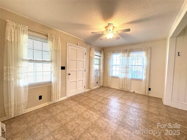 entryway featuring a textured ceiling, ceiling fan, baseboards, ornamental molding, and cooling unit