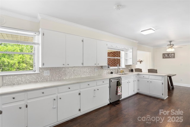 kitchen with light countertops, dishwasher, ornamental molding, a sink, and tasteful backsplash