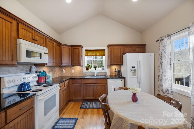 50 Honey Mountain Ln, Lake Toxaway, NC 28747 - kitchen featuring white appliances, lofted ceiling, light wood-style floors, decorative backsplash, and brown cabinets