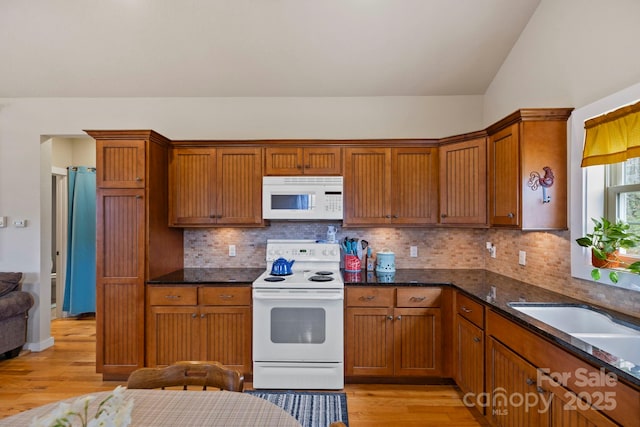 50 Honey Mountain Ln, Lake Toxaway, NC 28747 - kitchen with white appliances, light wood-style floors, backsplash, vaulted ceiling, and dark stone countertops