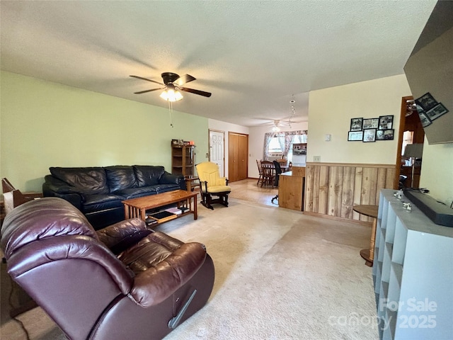 138 Friendship Dr, Ellenboro, NC 28040 - living room with ceiling fan, a textured ceiling, light colored carpet, a wainscoted wall, and wooden walls