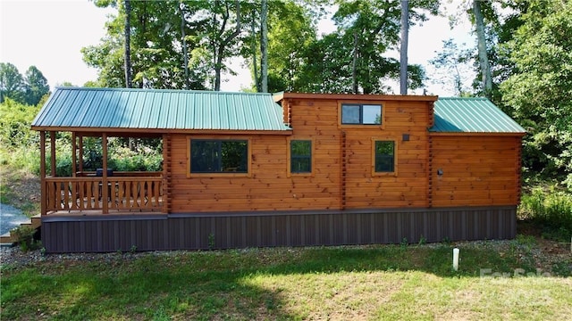 view of side of home featuring a lawn and metal roof