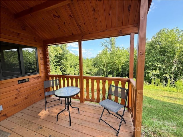 wooden deck featuring a lawn