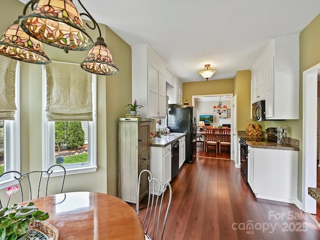 2516 Middlebridge Ln, Charlotte, NC 28270 - kitchen featuring dark wood finished floors, decorative light fixtures, white cabinets, black appliances, and dark countertops