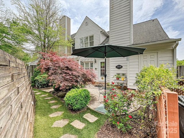 2516 Middlebridge Ln, Charlotte, NC 28270 - rear view of house featuring fence, a chimney, a shingled roof, and a patio