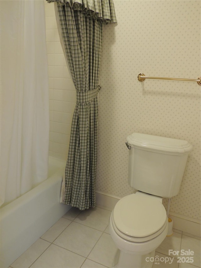 bathroom with tile patterned flooring, baseboards, wallpapered walls, and toilet