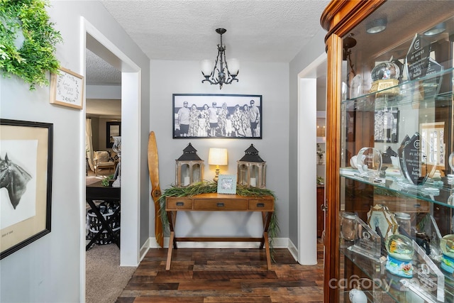 447 Henderson Rd, Chesnee, SC 29323 - hallway featuring a textured ceiling, wood finished floors, a notable chandelier, and baseboards