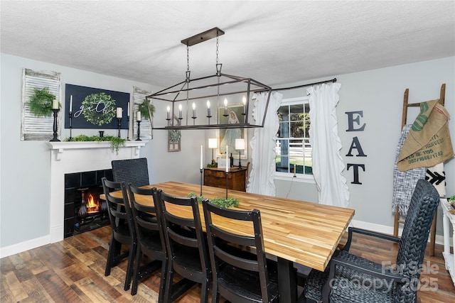 447 Henderson Rd, Chesnee, SC 29323 - dining room featuring baseboards, an inviting chandelier, a fireplace, a textured ceiling, and wood finished floors