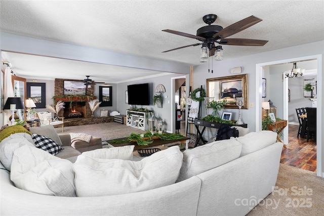 447 Henderson Rd, Chesnee, SC 29323 - living area with a large fireplace, ornamental molding, a textured ceiling, ceiling fan with notable chandelier, and wood finished floors