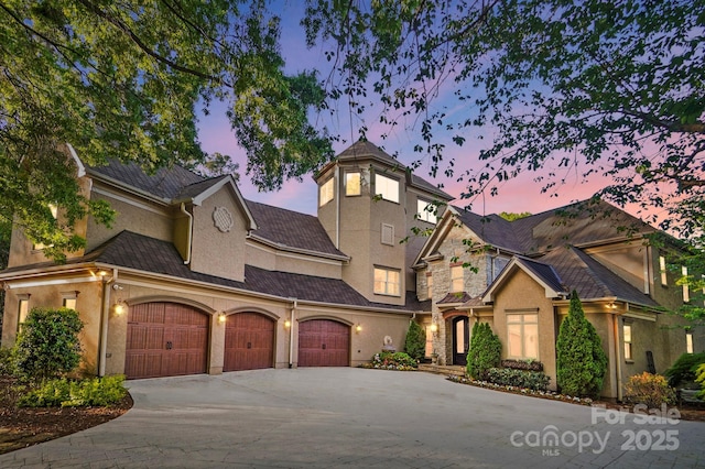 view of front of property with an attached garage, concrete driveway, and stucco siding