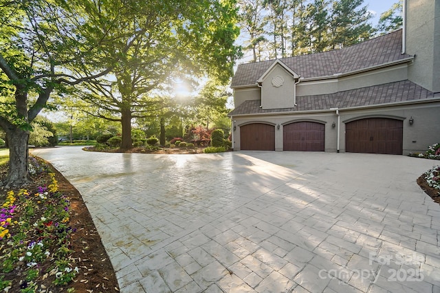 view of side of property featuring stucco siding and decorative driveway