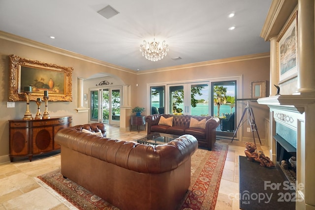 living room featuring crown molding, stone tile flooring, arched walkways, and a notable chandelier
