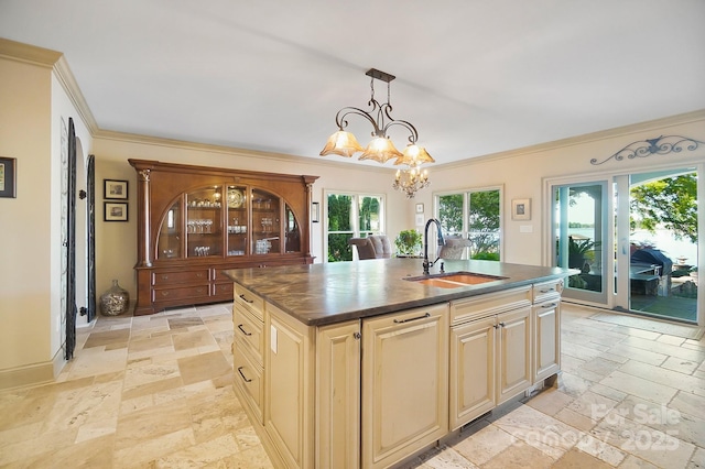 kitchen with a sink, dark countertops, stone tile floors, and cream cabinets