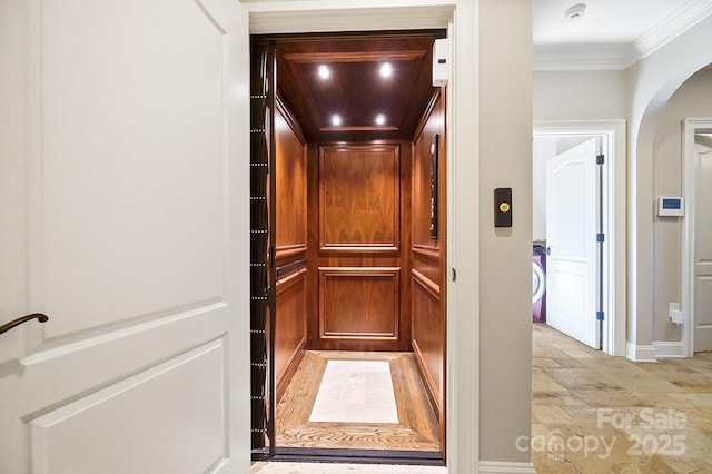 room details with arched walkways, crown molding, baseboards, and elevator