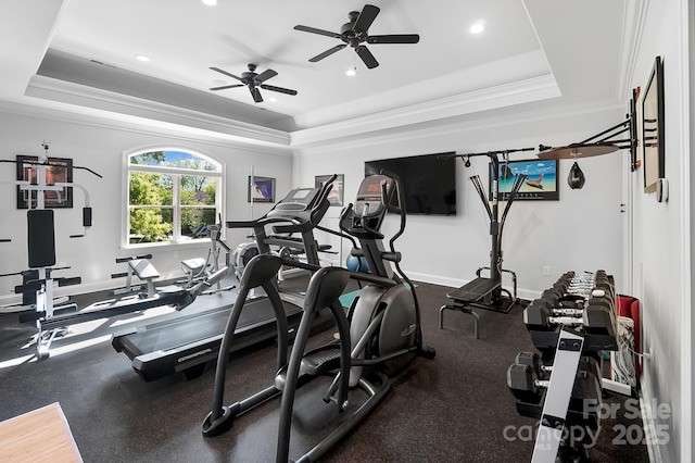 gym with baseboards, ornamental molding, recessed lighting, a ceiling fan, and a raised ceiling