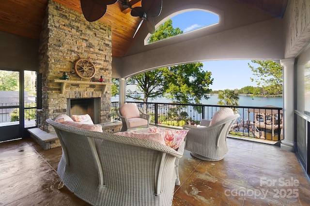 exterior space with a water view, an outdoor living space with a fireplace, and a ceiling fan