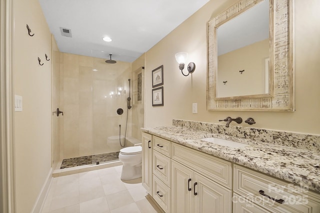 bathroom with vanity, tile patterned flooring, toilet, tiled shower, and visible vents