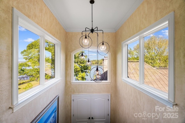 doorway to outside with an inviting chandelier, ornamental molding, and a healthy amount of sunlight
