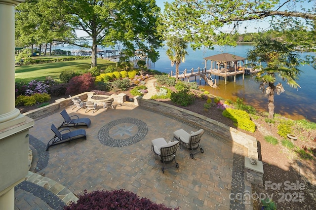 view of patio featuring a water view, an outdoor fire pit, and a dock
