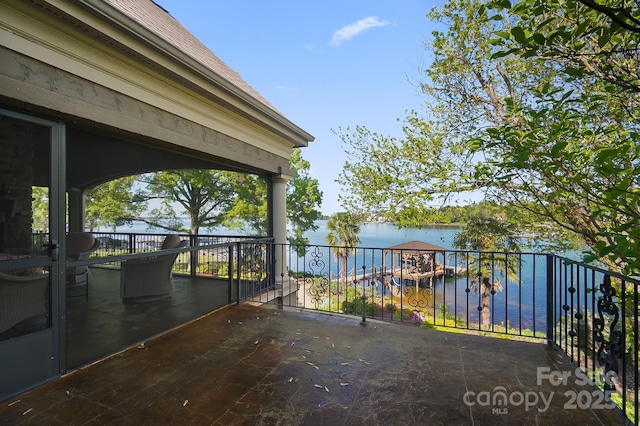 view of patio with a water view and a balcony