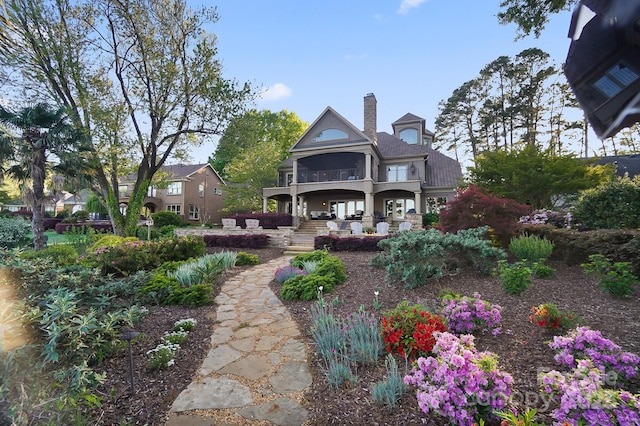 back of property featuring a chimney and a balcony