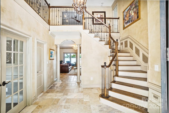 20428 Island Forest Dr, Cornelius, NC 28031 - foyer entrance featuring ornate columns, a towering ceiling, stone tile flooring, ornamental molding, and baseboards