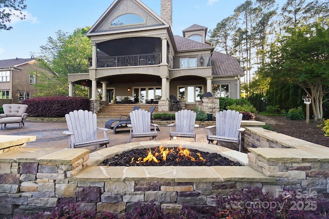 20428 Island Forest Dr, Cornelius, NC 28031 - rear view of property with a fire pit, a balcony, a patio area, a chimney, and stucco siding