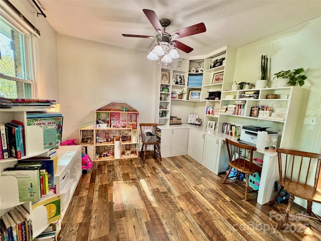 game room with a textured ceiling, wood finished floors, and ceiling fan