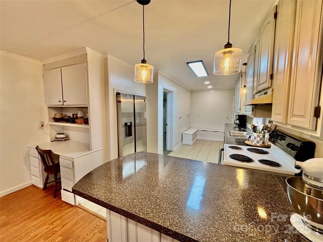 kitchen featuring stainless steel refrigerator with ice dispenser, range with electric stovetop, dark countertops, a peninsula, and under cabinet range hood