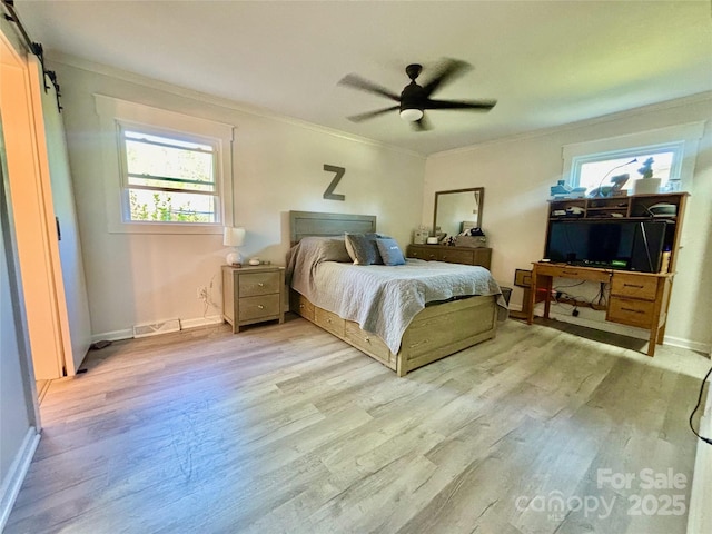 bedroom with visible vents, baseboards, a barn door, light wood-style floors, and crown molding