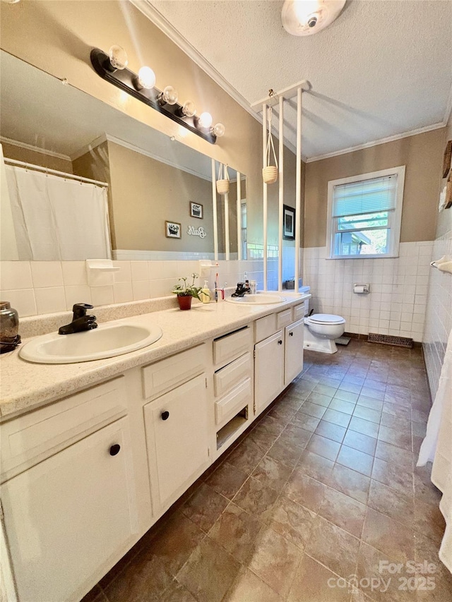 full bath featuring a sink, toilet, double vanity, and a textured ceiling