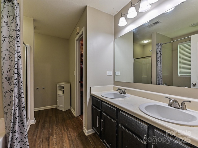 full bath featuring visible vents, a sink, curtained shower, and wood finished floors