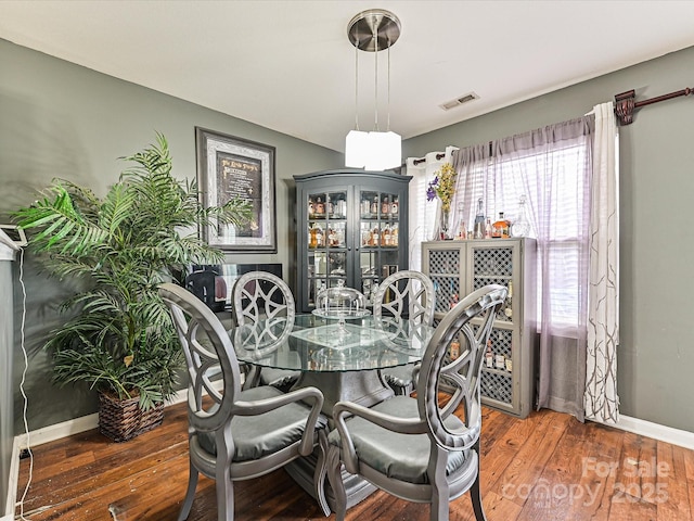 dining room with wood-type flooring, baseboards, and visible vents