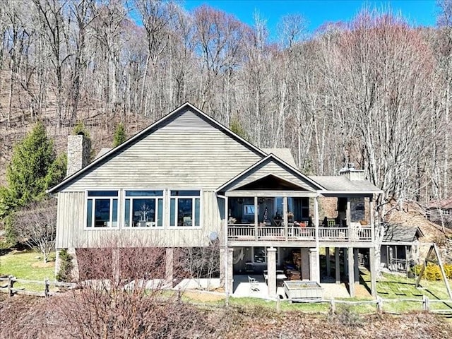 116 Dana Rd, Waynesville, NC 28786 - back of property with a view of trees, fence, a patio, and a chimney