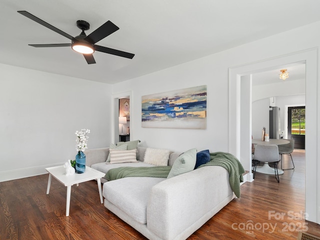 living area with wood finished floors, baseboards, and ceiling fan