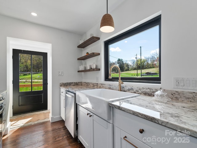 kitchen featuring a sink, white cabinets, stainless steel appliances, dark wood finished floors, and light stone countertops