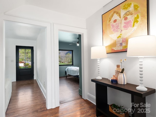 corridor with baseboards and dark wood-style floors