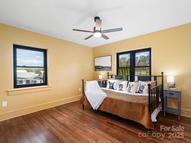 bedroom featuring baseboards, a ceiling fan, wood finished floors, and visible vents