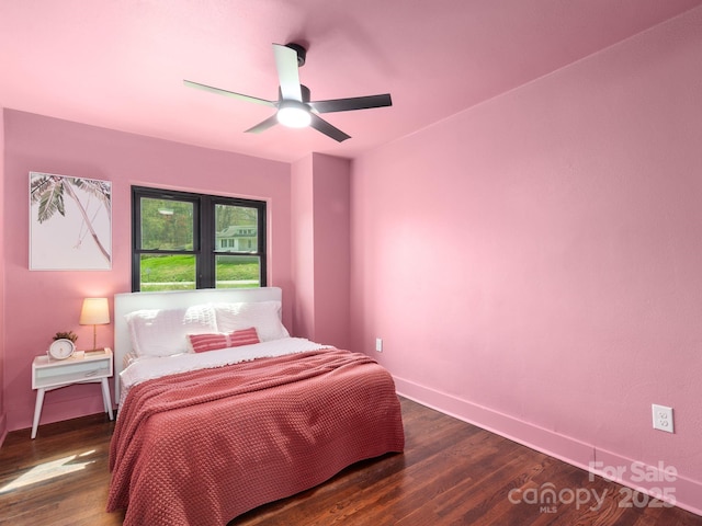 bedroom with dark wood finished floors, a ceiling fan, and baseboards