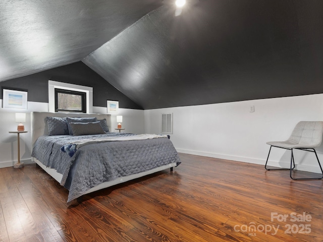 bedroom featuring vaulted ceiling, wood finished floors, visible vents, and baseboards